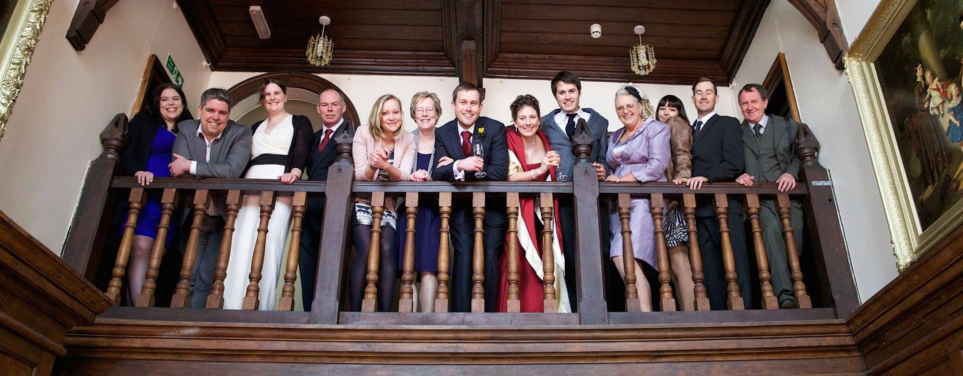 Bride and groom with guest on gallery balcony